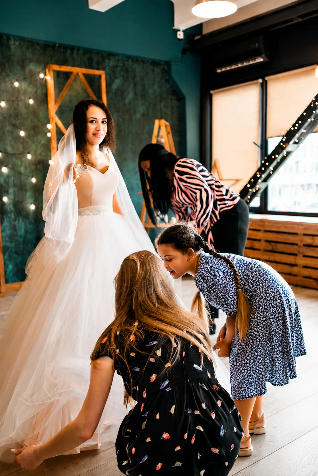 Bride attending a wedding dress fitting with family and friends in a bridal boutique