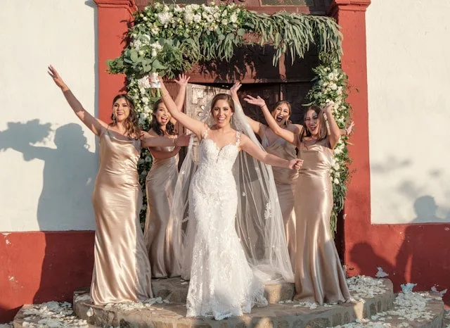 Bride and four bridesmaids smiling and posing together on wedding day