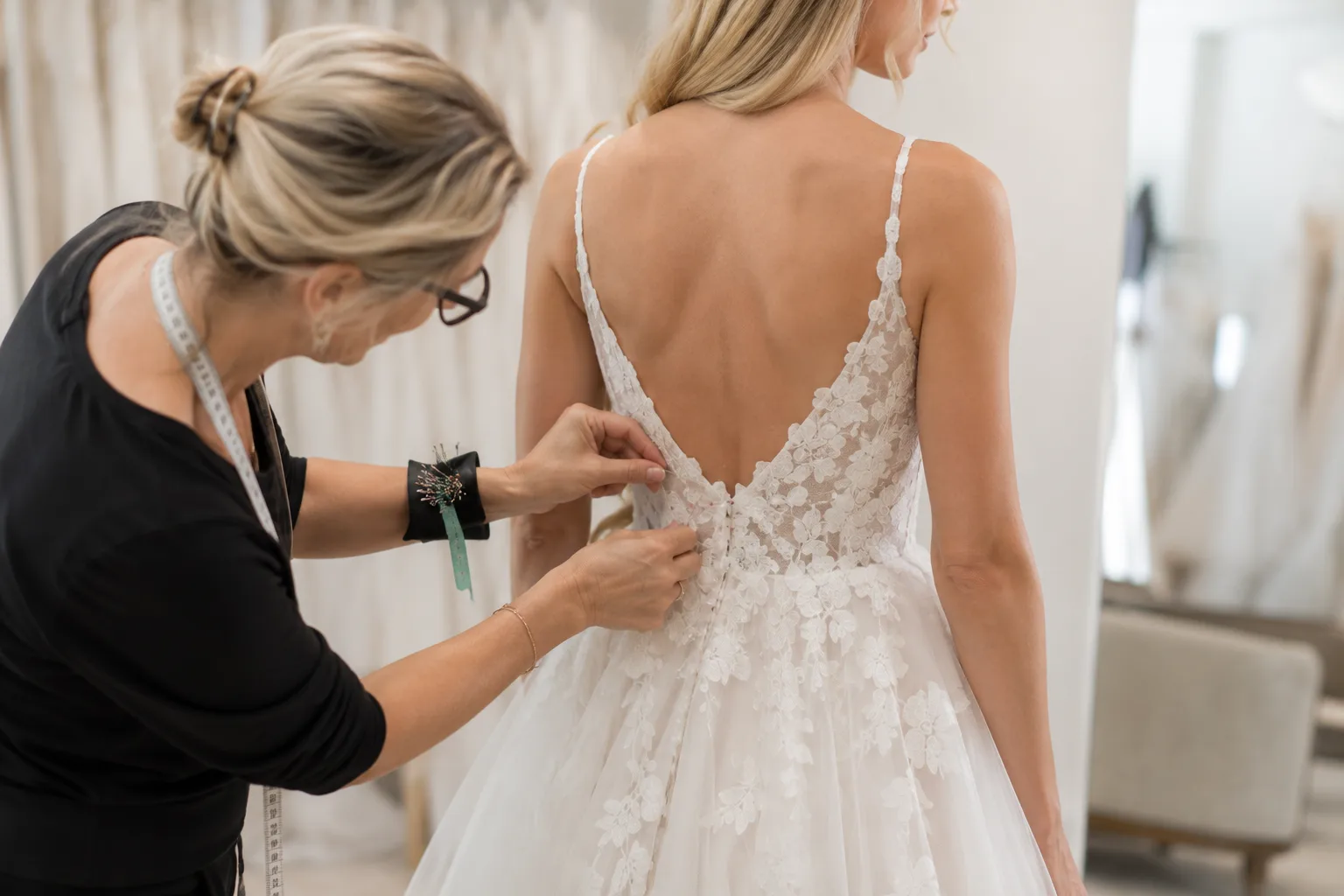 Bridal seamstress pinning a wedding gown during alterations