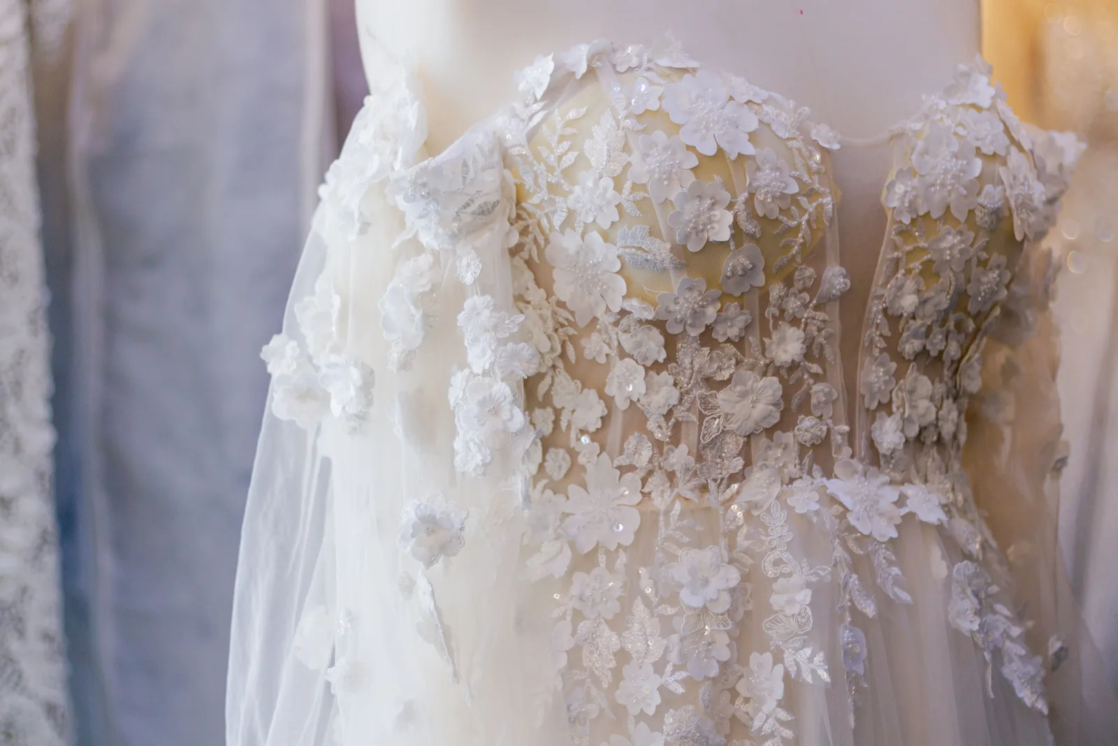 Detailed lace wedding dress with floral appliqués before bridal alterations