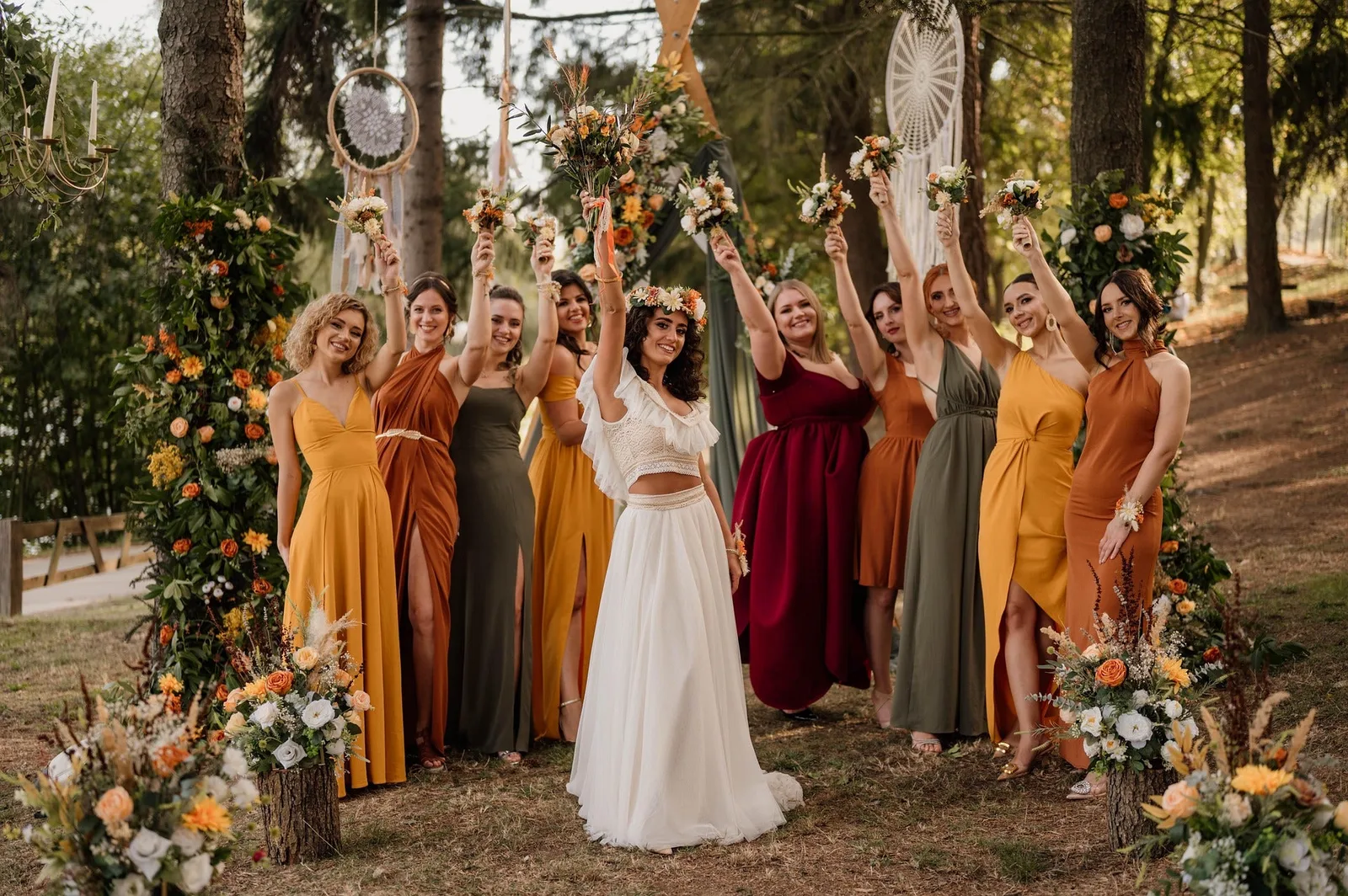 New Zealand bohemian bride posing with nine bridesmaids at outdoor wedding celebration